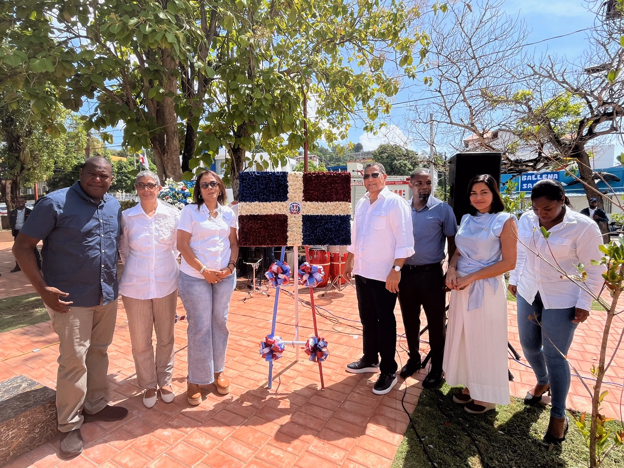 Directivos del Instituto Duartiano e invitados junto a la bandera floral